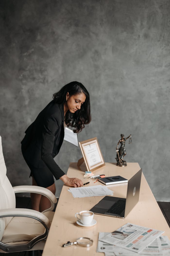 services-03 A businesswoman in a corporate setting organizing papers on her desk.